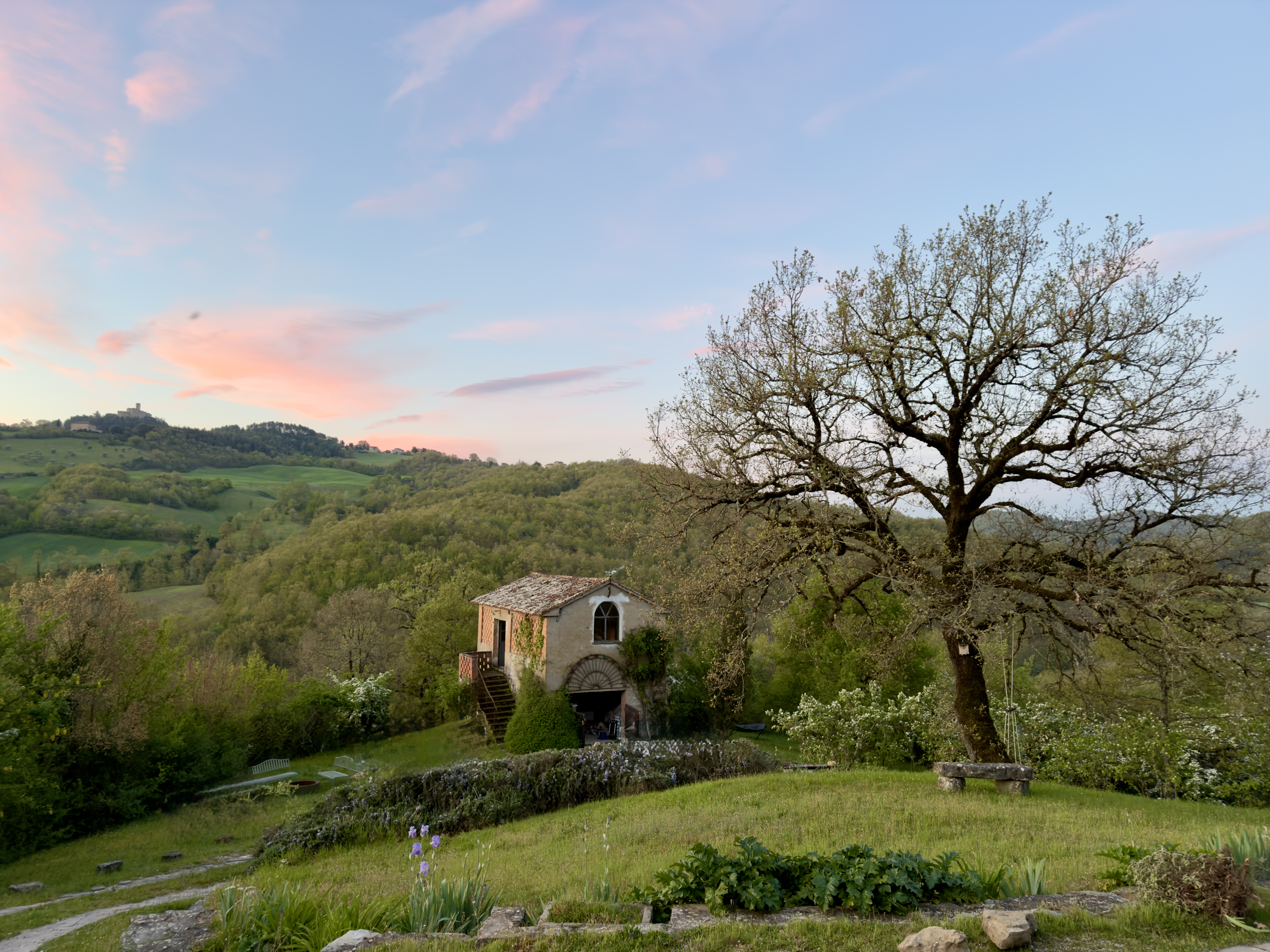 Guest house at sunset with pink sky and rolling Umbrian hills